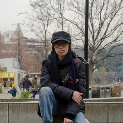 Sonic Lee outdoors, wearing glasses and a dark coat.